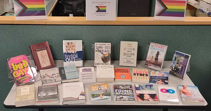 Table full of LGBTQIA+ related books.